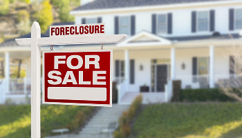 Foreclosure for sale sign in front of a house
